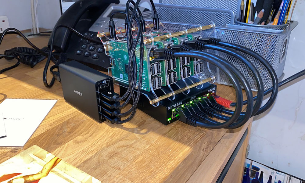 A rather bad photo of the cluster on my desk, taken before I realised I could power the switch from the Anker PowerPort as well.
